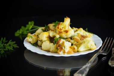 Siyah arka planda iştah açıcı kızarmış karnabahar..