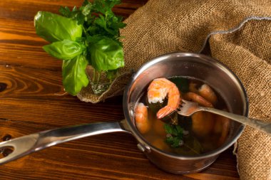 Tahta bir masada, tavada kırmızı karides yemeye hazır..