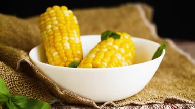 Beyaz bir tabakta iki tane haşlanmış mısır..