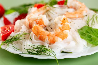 Karides ve sebzeli haşlanmış pirinç eriştesi sunumu..