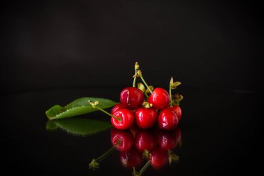 Siyah arka planda bir avuç olgun kırmızı kiraz..