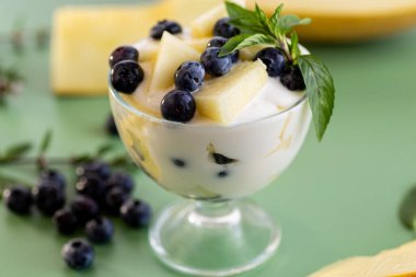 Yumuşak yoğurt, kavun parçaları ve taze yaban mersini..