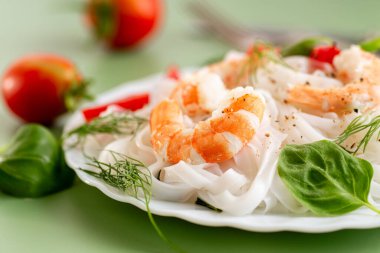 Yeşil bir tabanda karides ve fesleğen minimalist kompozisyonu.