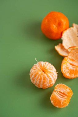 Doğal narenciye kabuğuyla sıralanmış parlak sulu mandalina meyveleri..