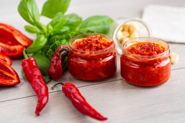 Ahşap yüzeyde sarımsaklı ve fesleğenli lezzetli biber ezmesi..