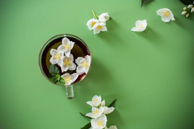 Yukarıdan cam çaydanlıkta yaseminli yeşil çay.