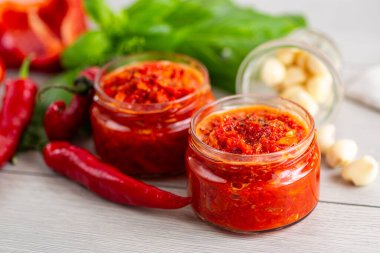 Acı biberli taze baharat sosu ve masada bitkiler..