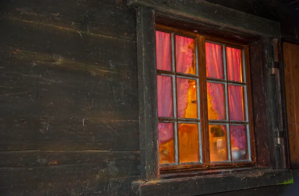 Heimelige Atmosphäre hinter dem Fenster mit Verglasungsstangen eines Blockhauses — Stockfoto