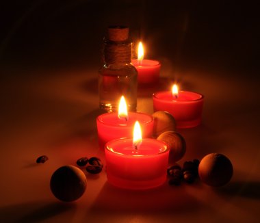 spa kompozisyonu. kokulu mumlar, kahve çekirdekleri, aromatik ahşap topları ve bir stoper ile cam sürahi yağ. Fotoğraf karanlık bir anahtarla yürütülür. kısmen renkli fotoğraf.