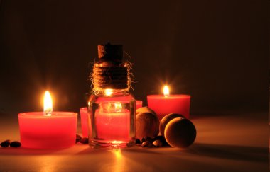 spa kompozisyonu. kokulu mumlar, kahve çekirdekleri, aromatik ahşap topları ve bir stoper ile cam sürahi yağ. Fotoğraf karanlık bir anahtarla yürütülür. kısmen renkli fotoğraf.