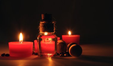 spa kompozisyonu. kokulu mumlar, kahve çekirdekleri, aromatik ahşap topları ve bir stoper ile cam sürahi yağ. Fotoğraf karanlık bir anahtarla yürütülür. kısmen renkli fotoğraf.