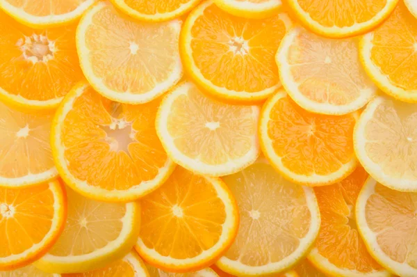 Citrus background. juicy slices of lemon and orange cover the entire surface. — Stock Photo, Image