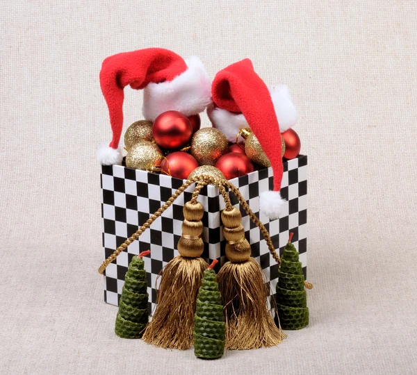 礼品盒多米诺骨牌的风格 充满了圣诞球 由金线流苏的帽子圣诞老人 Claus Decoration — 图库照片
