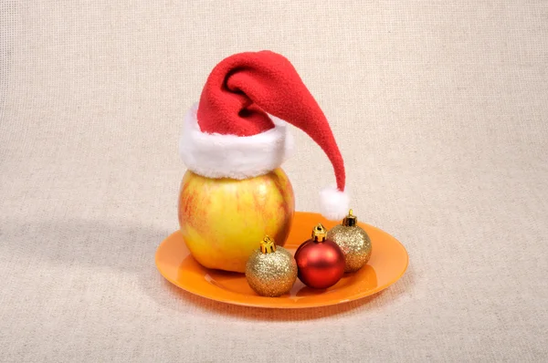 Apfel Mit Weihnachtsmütze Und Christbaumkugeln — Stockfoto