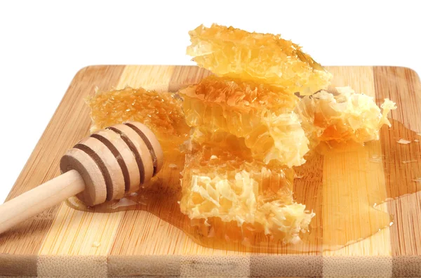 Honeycomb honey with diper on a wooden cutting board, white background — Stock Photo, Image