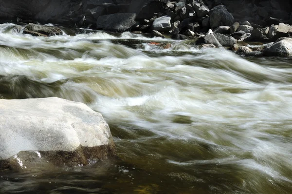 快速流动的一条山涧河流。部分有色的照片. — 图库照片