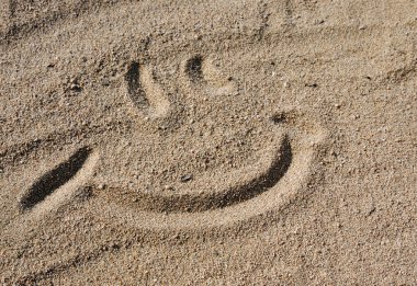 Sandy sanat, elle çizilmiş duygu işareti kum üzerinde