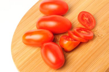 Bambu kesme tahtası üzerinde kırmızı kiraz domates