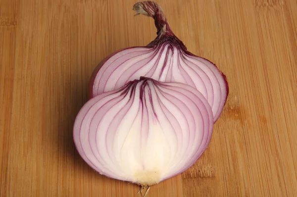 Cebolla roja sobre tabla de cortar de bambú — Foto de Stock