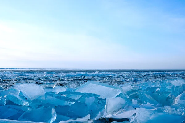 冬天。冰上表面的贝加尔湖。在冰表面的裂缝。冰风暴。用深蓝色色调的照片. — 图库照片