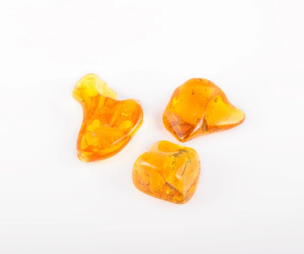 Glanzende amber edelsteen op wit. Soft focus ondervraagt foto afgezwakt — Stockfoto
