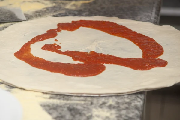 Man chef-kok met rauwe pizza. — Stockfoto