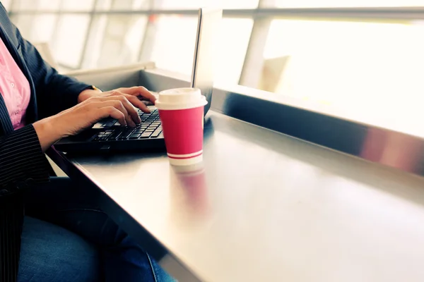 Vrouw met behulp van apparaten in luchthaven — Stockfoto