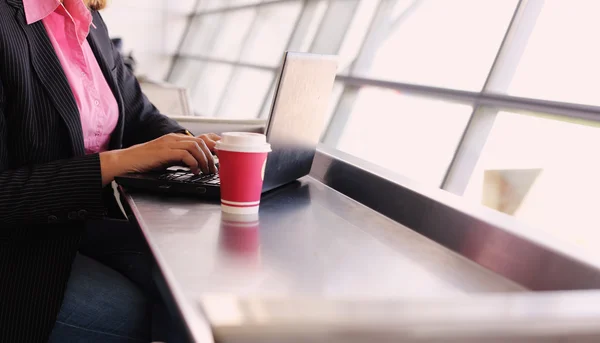 Mulher usando dispositivos no aeroporto — Fotografia de Stock