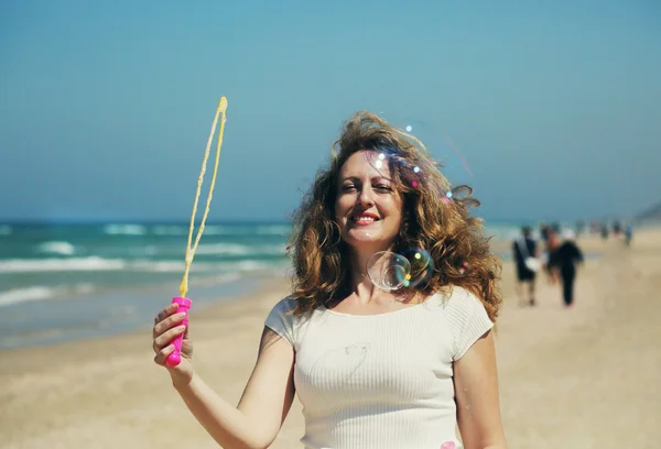 Beautiful woman blowing bubbles — Stock Photo, Image