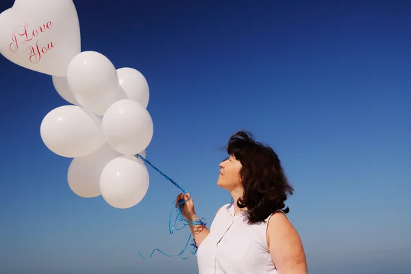 Frau mit weißen Luftballons — Stockfoto