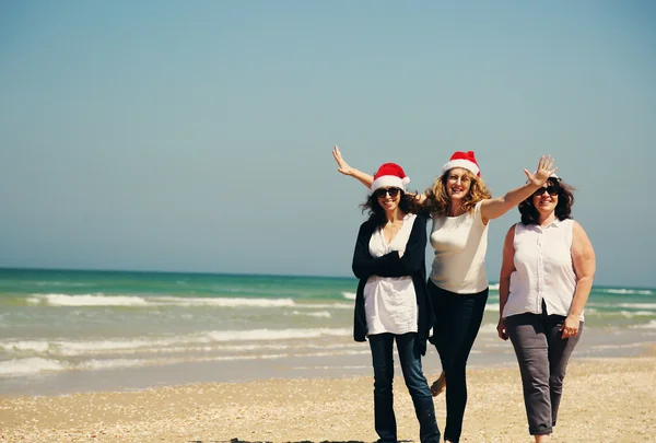 Femmes dans les chapeaux de Noël sur le bord de la mer — Photo