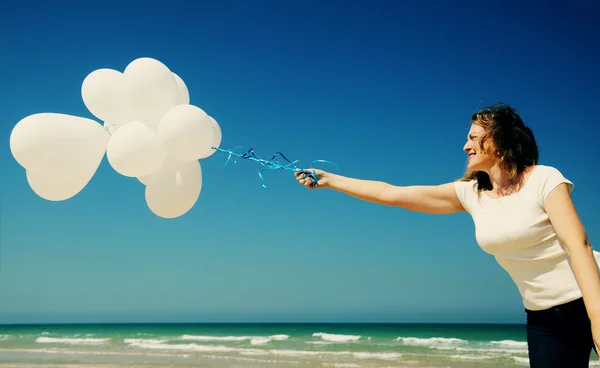 Woman holding white balloons — Stock Photo, Image