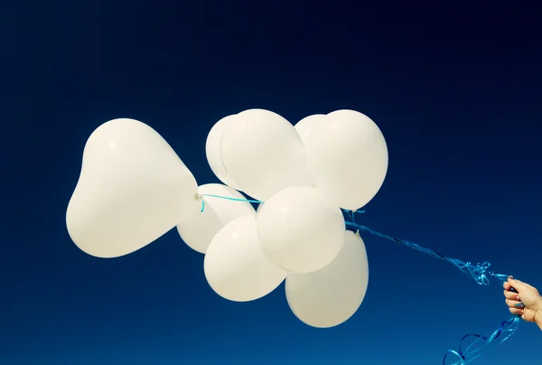 Witte ballonnen in vrouwelijke hand — Stockfoto