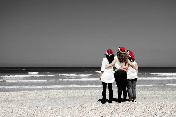 Ženy v vánoční čepice na moře — Stock fotografie