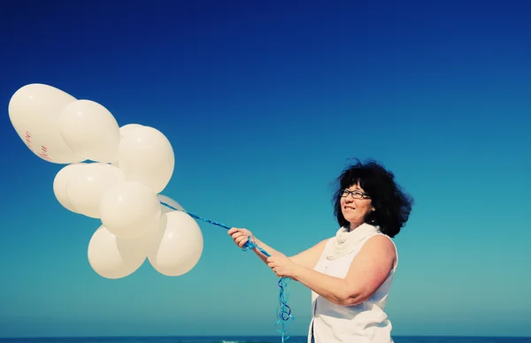 Vrouw bedrijf witte ballonnen — Stockfoto