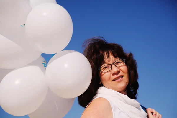Woman holding white balloons — Stock Photo, Image
