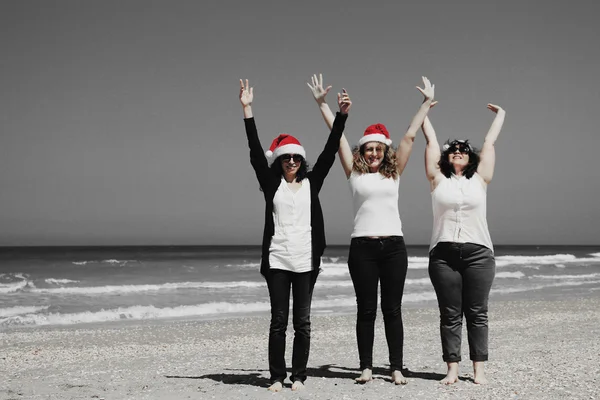 Femmes dans les chapeaux de Noël sur le bord de la mer — Photo