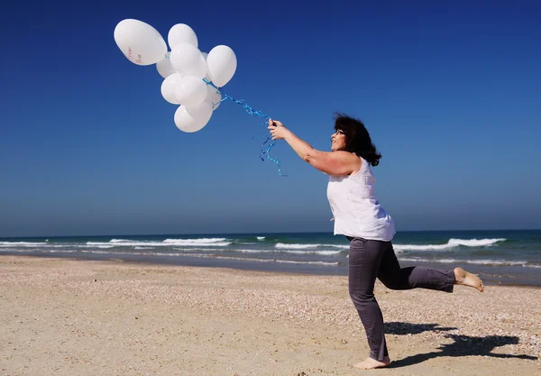 Femme tenant des ballons blancs — Photo