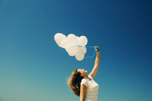 Kvinna anläggning vita ballonger — Stockfoto