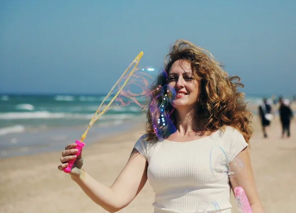 Beautiful woman blowing bubbles — Stock Photo, Image