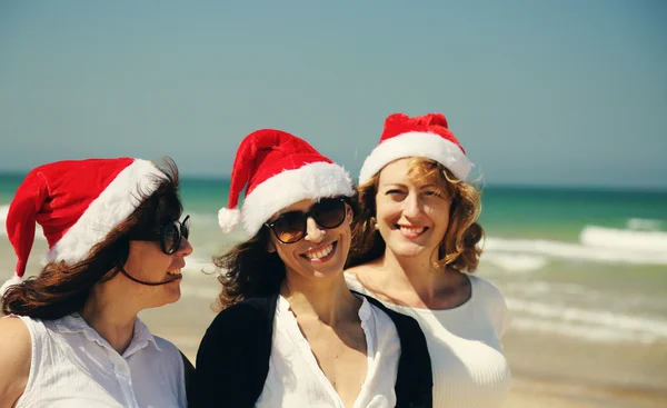 Femmes dans les chapeaux de Noël sur le bord de la mer — Photo