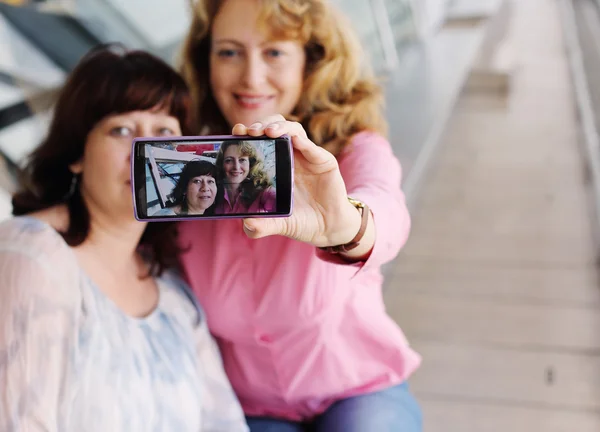 Kvinnor i jul hattar gör selfie — Stockfoto