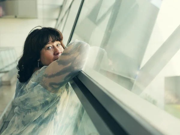 Frau steht am Fenster — Stockfoto