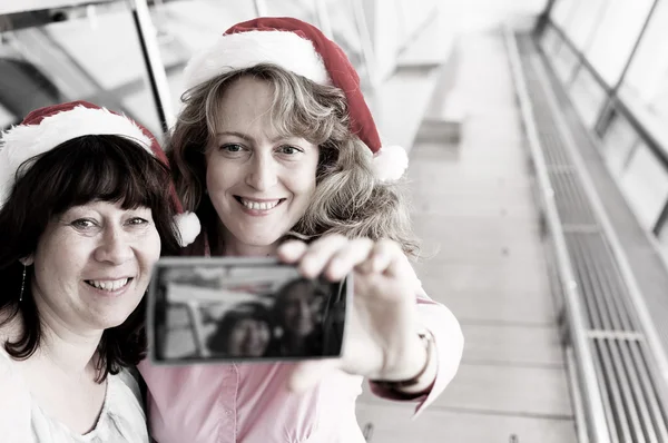 Mulheres em chapéus de Natal fazendo selfie — Fotografia de Stock