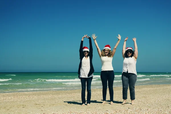 Femmes portant des chapeaux de Noël sur le bord de la mer — Photo