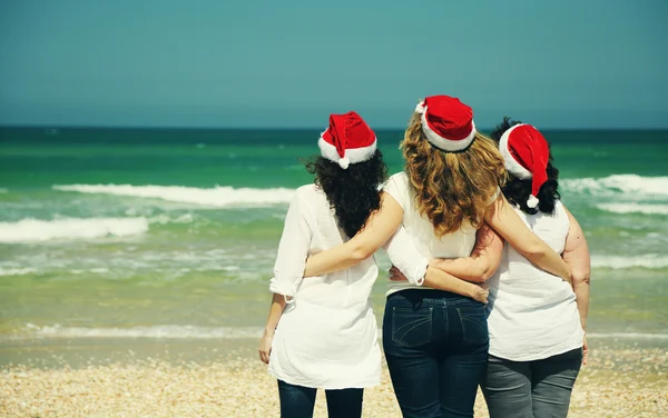 Femmes portant des chapeaux de Noël sur le bord de la mer — Photo