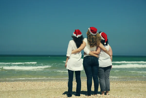 Femmes portant des chapeaux de Noël sur le bord de la mer — Photo