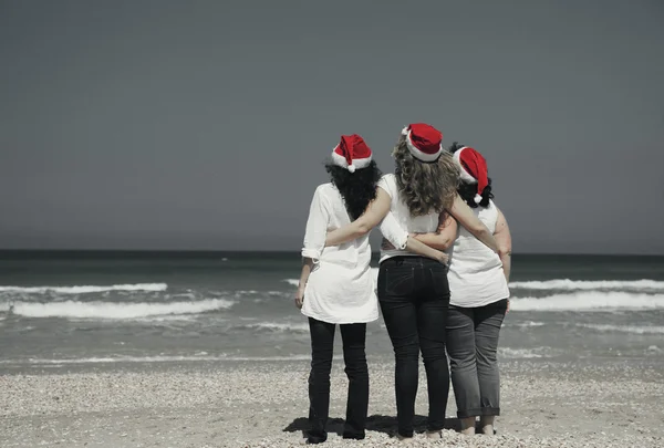 Frauen mit Weihnachtsmützen am Meer — Stockfoto