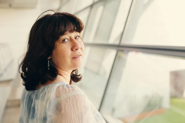 Woman standing near the window — Stock Photo, Image