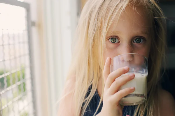 लड़की दूध का ग्लास पकड़े हुए — स्टॉक फ़ोटो, इमेज